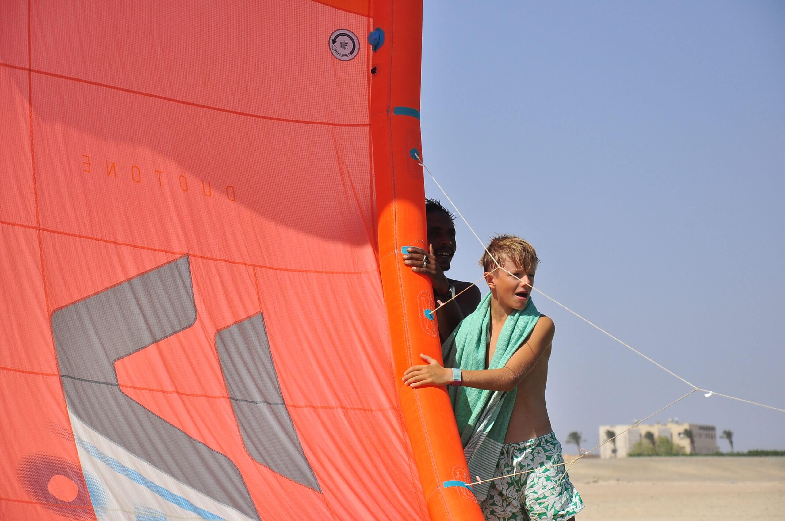 Two people beside a red kite canopy at KiteMood