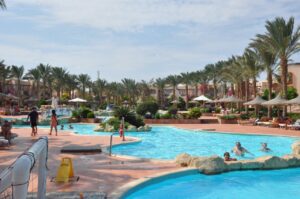 Landscaped resort gardens with palm trees and beach umbrellas